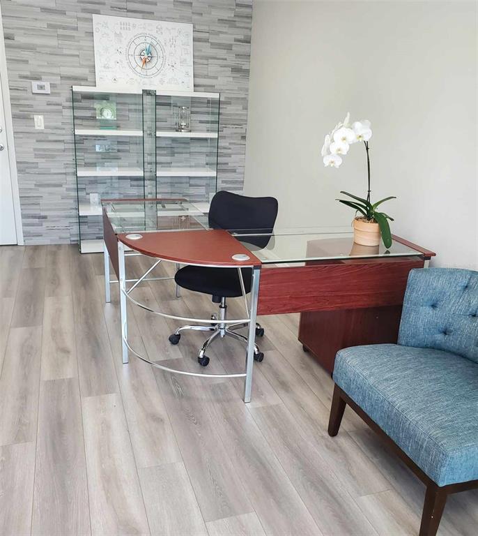A modern office features a glass-topped desk, a black chair, and a blue accent chair — 2730 WORTH AVENUE UNIT 8, ENGLEWOOD, FL