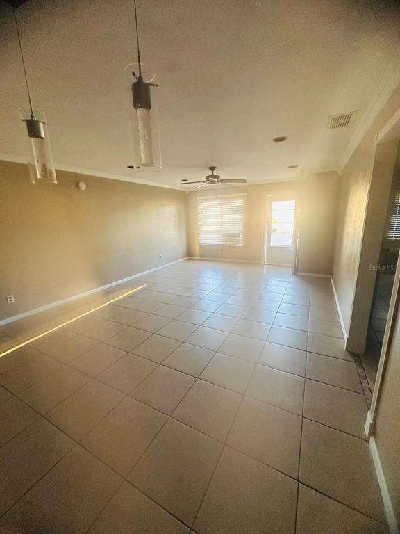 An open-concept living area features light-colored tile flooring, two pendant lights, and a ceiling fan — 502 WINTER TERRACE UNIT 121, WINTER HAVEN, FL