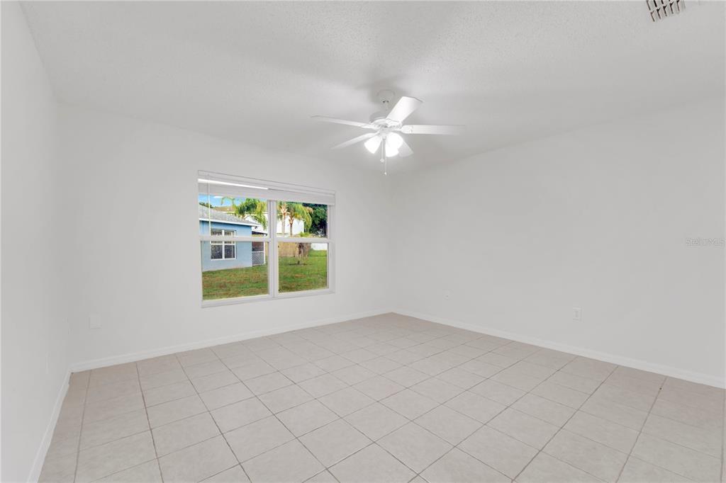 An empty bedroom features white walls, light-colored floor tiles, and a ceiling fan — 13403 COPPER HEAD DRIVE, RIVERVIEW, FL