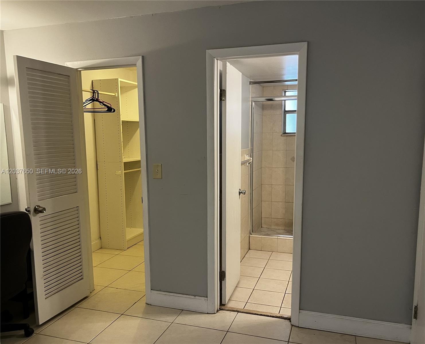 A room features two doorways leading to a walk-in closet and a tiled shower — 7000 Nova Dr # 103E, Davie FL 33317, DAVIE, FL