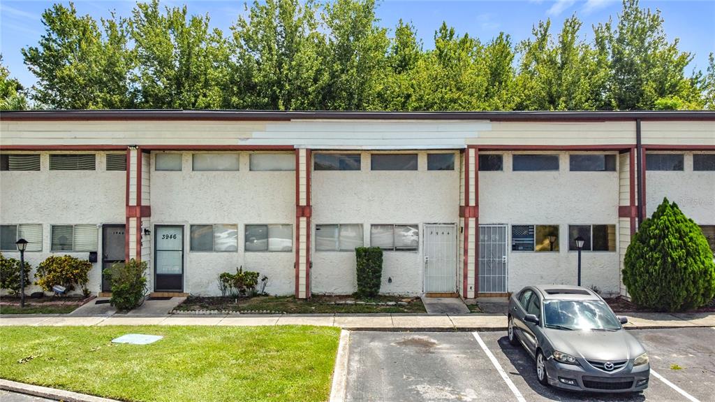 A two-story apartment building exterior with stucco walls, horizontal windows, and a parking lot — 3944 CRAYRICH CIRCLE UNIT A-4, ORLANDO, FL
