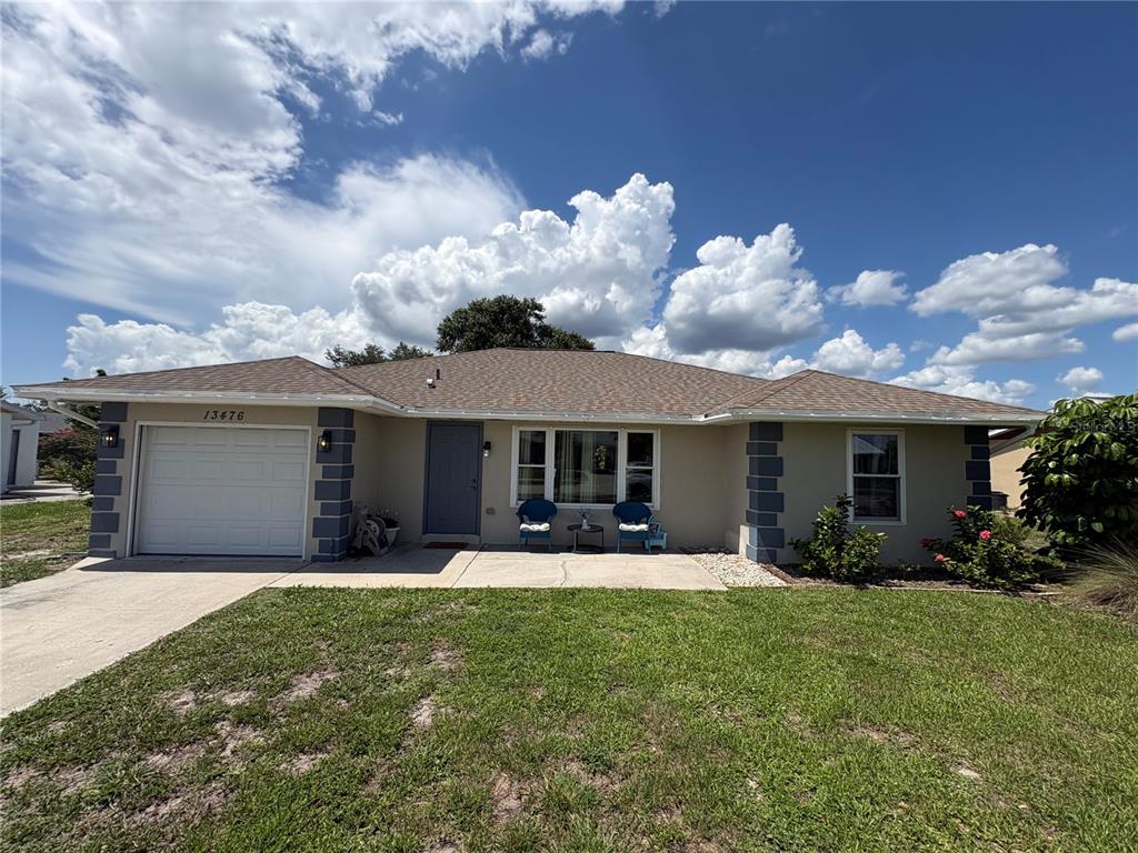 A single-story house with a beige exterior, a gray front door, and a one-car garage — 13476 ROMFORD AVENUE, PORT CHARLOTTE, FL