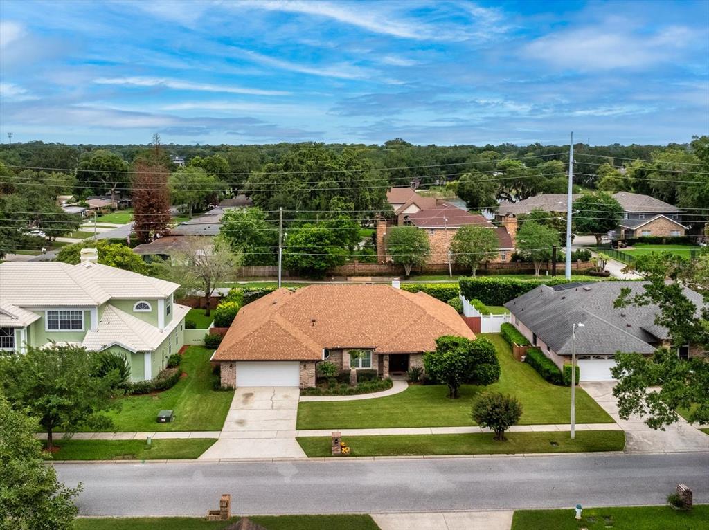 An aerial view shows a single-story house with a brown roof and a front driveway — 4025 CONWAY PLACE CIRCLE, ORLANDO, FL
