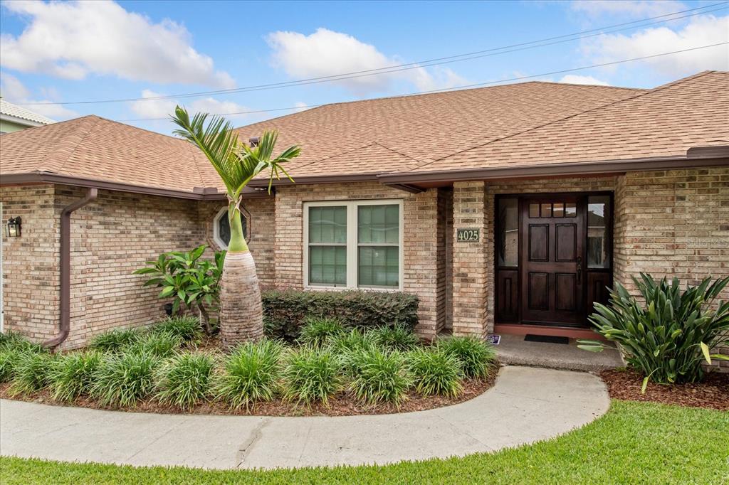 A brick house exterior features a front door, a palm tree, and a curved walkway — 4025 CONWAY PLACE CIRCLE, ORLANDO, FL