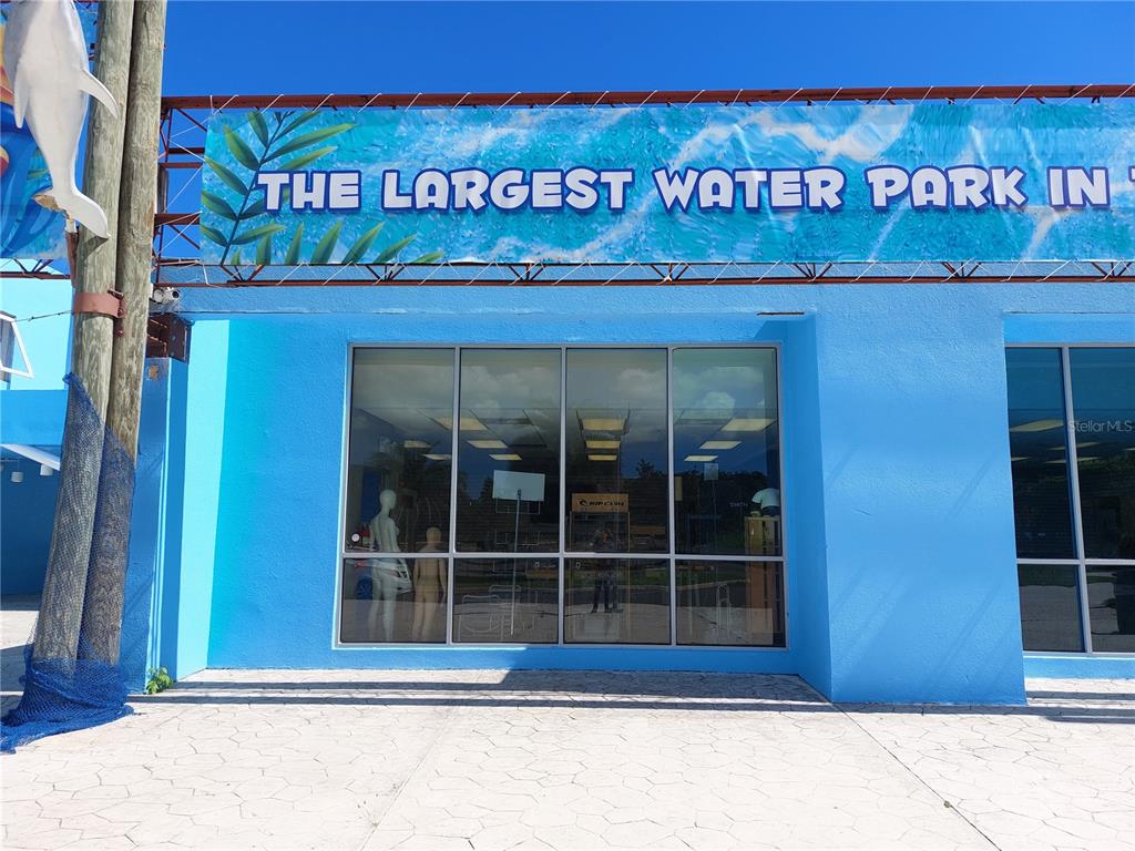 The exterior of a bright blue building features a large sign and glass storefront windows — Bo Caín Alto LOCAL #2 SURF N' FUN WATER PARK, SAN GERMAN, PR