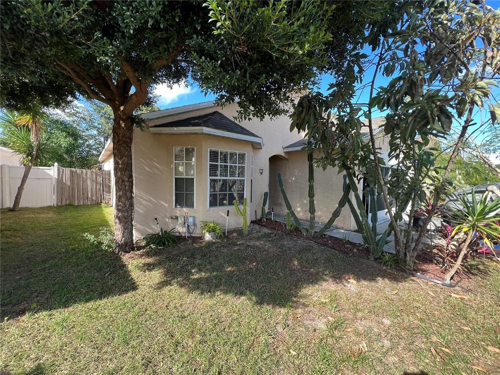 A single-story house with a beige stucco exterior, large windows, and various cacti in front — 2814 PALM ISLE WAY, ORLANDO, FL