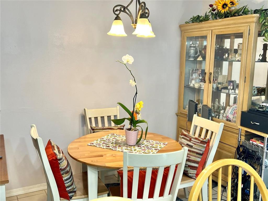 A dining area features a round wooden table, four white chairs, and a glass-fronted hutch — 2814 PALM ISLE WAY, ORLANDO, FL