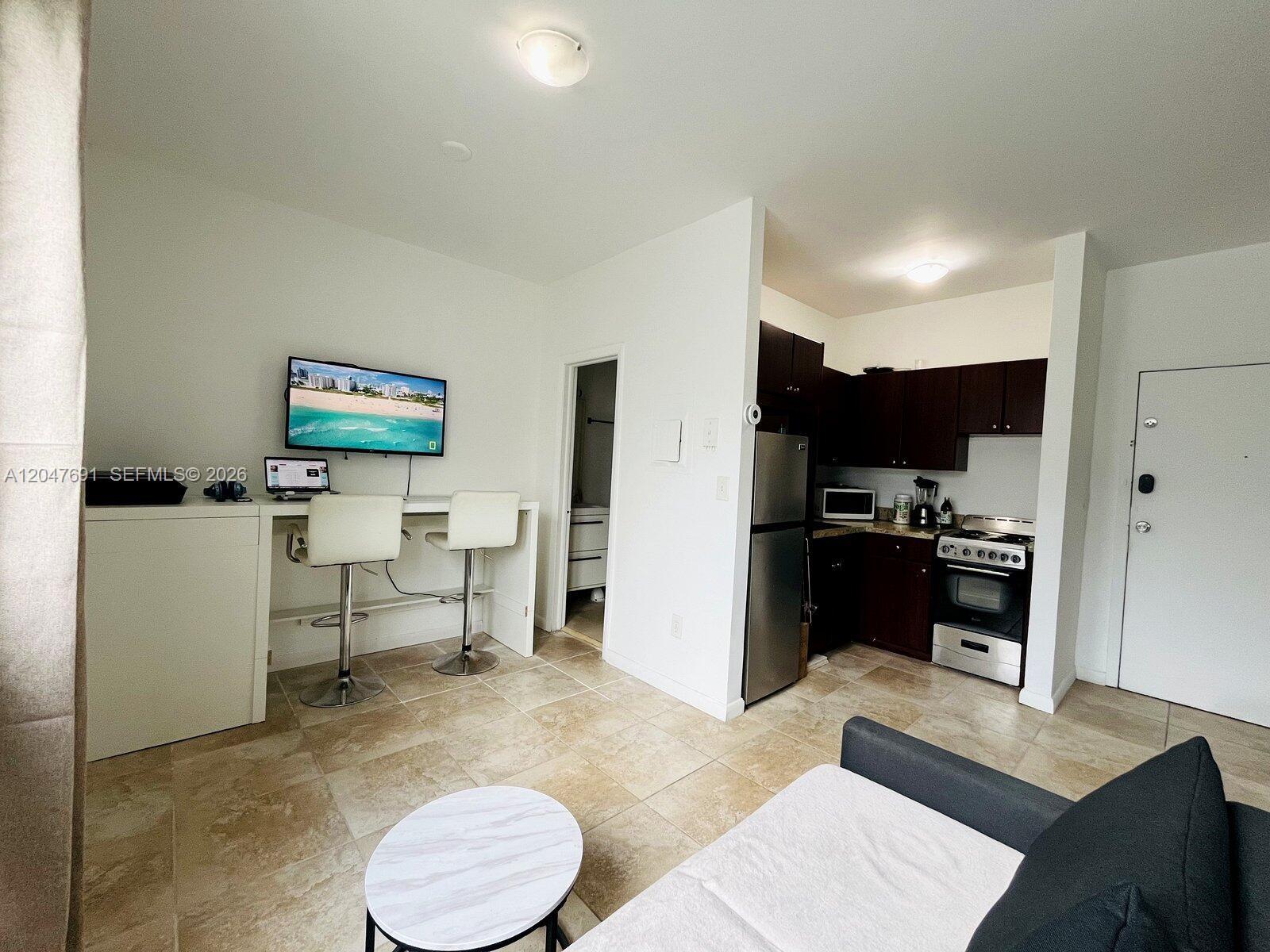 A studio apartment features a kitchenette, a breakfast bar with two stools, and tile flooring — 842 Meridian # 2F, Miami Beach FL 33139, MIAMI BEACH, FL