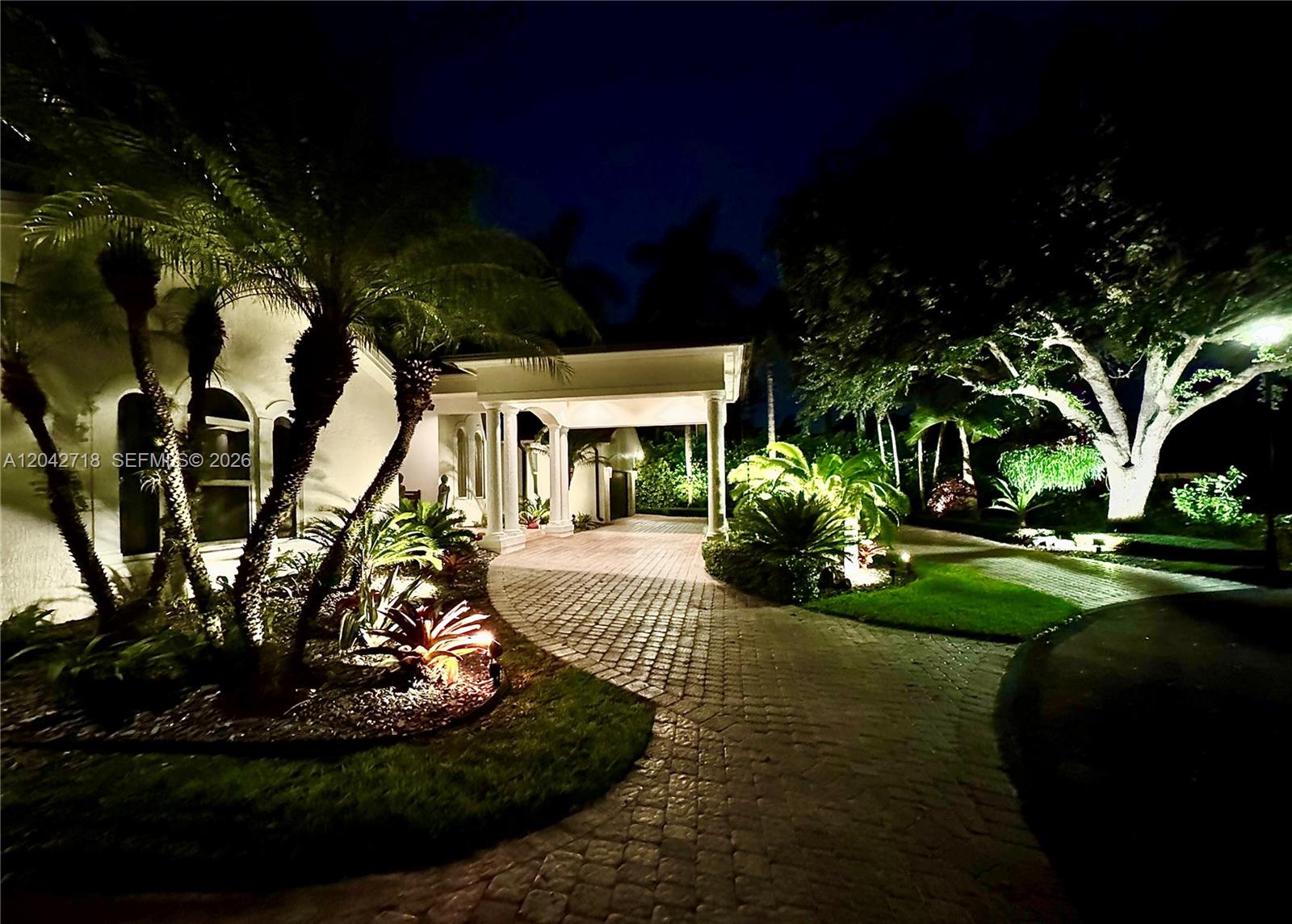A paved driveway leads to a covered entrance of a house at night — 9662 SW 123rd St, Miami FL 33176, MIAMI, FL