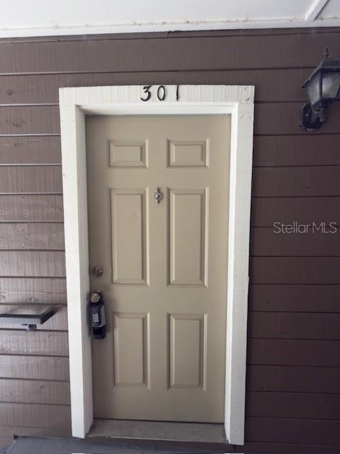 A tan front door with a keypad lock and the number 301 above the frame — 224 AFTON SQUARE UNIT 8-301, ALTAMONTE SPRINGS, FL