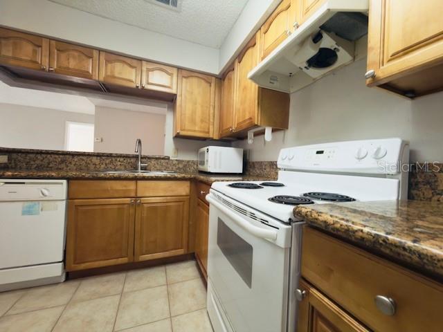 A kitchen features wood cabinets, granite countertops, a white stove, and a white dishwasher — 224 AFTON SQUARE UNIT 8-301, ALTAMONTE SPRINGS, FL