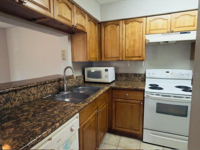 A kitchen features wood cabinets, granite countertops, a white stove, and a double-basin sink — 224 AFTON SQUARE UNIT 8-301, ALTAMONTE SPRINGS, FL