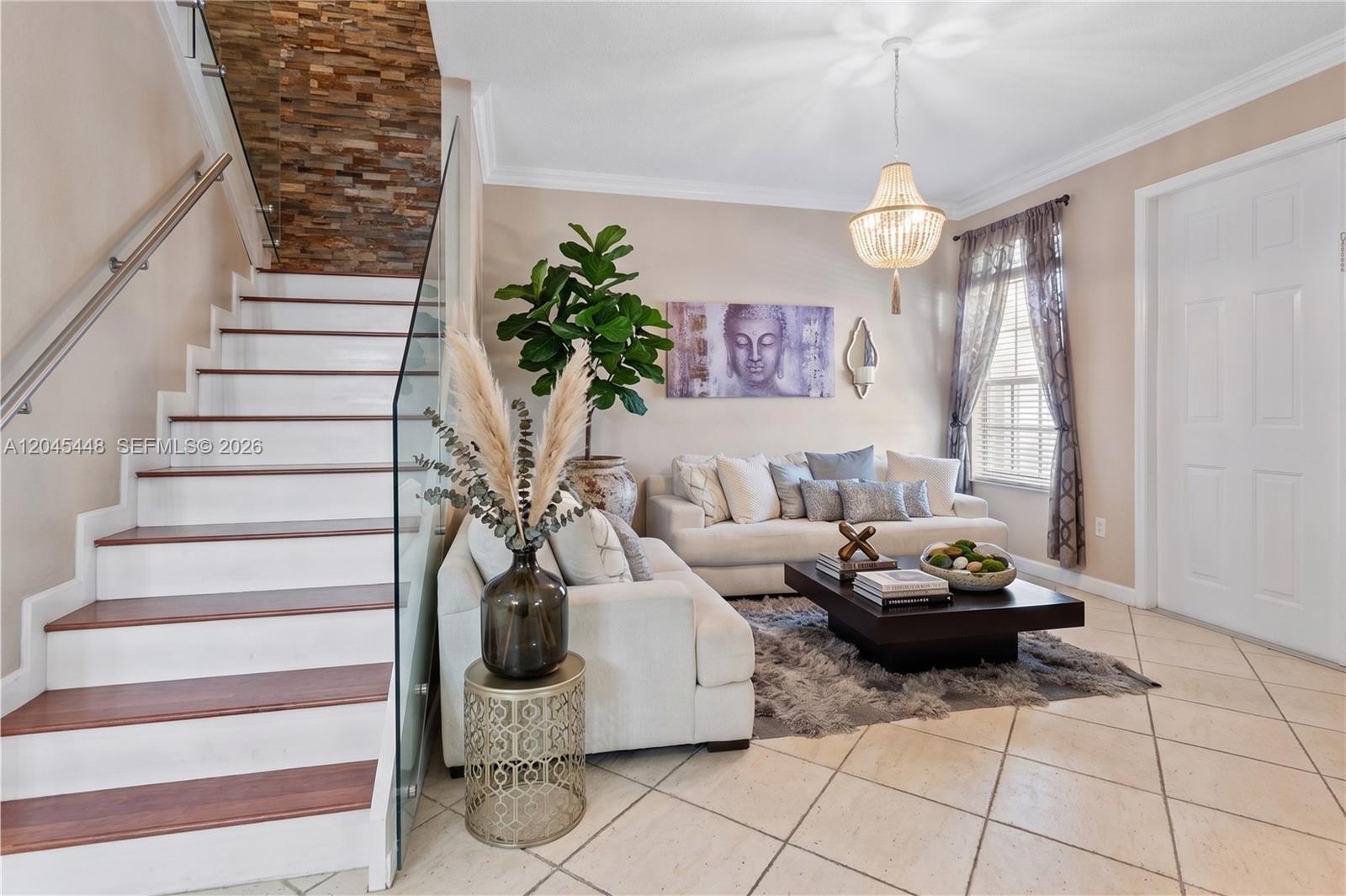 A living room features a staircase with a glass railing, a sofa, and a chandelier — 8133 SW 118th Ct # 8133, Miami FL 33183, MIAMI, FL