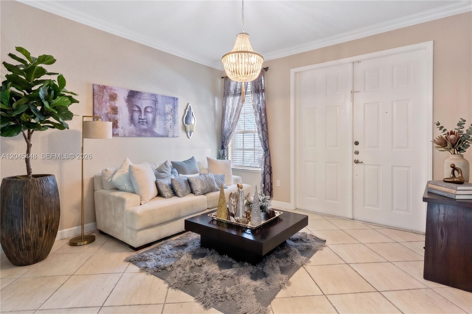 A living room features a white sofa, a dark coffee table, and a large chandelier — 8133 SW 118th Ct # 8133, Miami FL 33183, MIAMI, FL