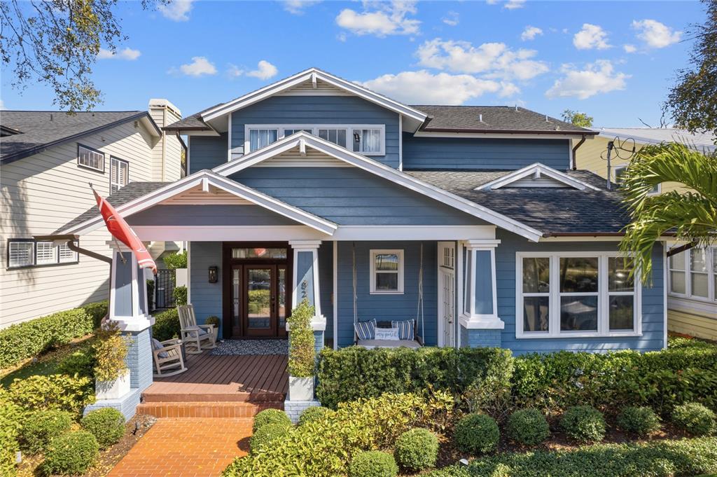 A blue two-story house features a front porch with a swing and rocking chairs — 824 S ROME AVENUE, TAMPA, FL