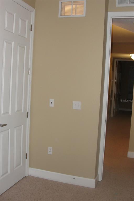 A beige wall features a door, a power outlet, light switches, and a ceiling vent — 2075 HERITAGE KEY BOULEVARD, KISSIMMEE, FL