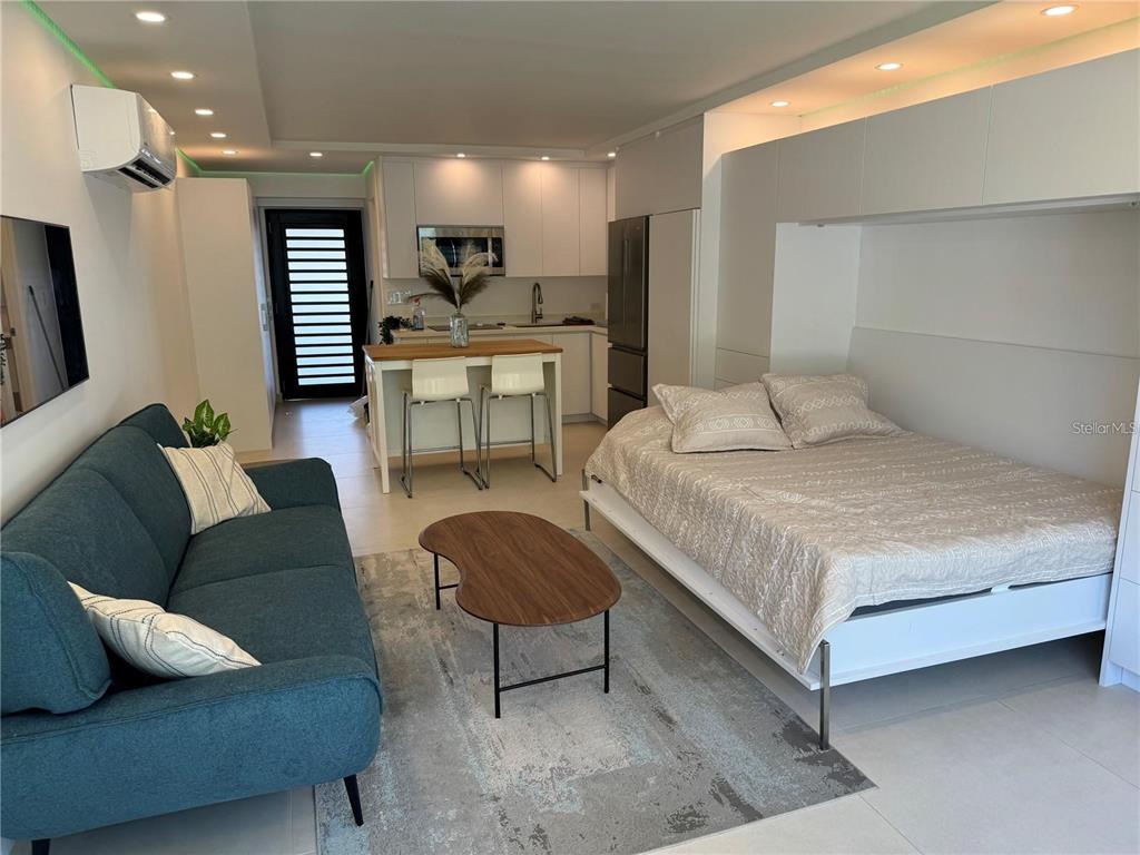 A studio apartment features a kitchen, a sofa, and a bed with white cabinetry — 4633 AVE ISLA VERDE UNIT L202, CAROLINA, PR