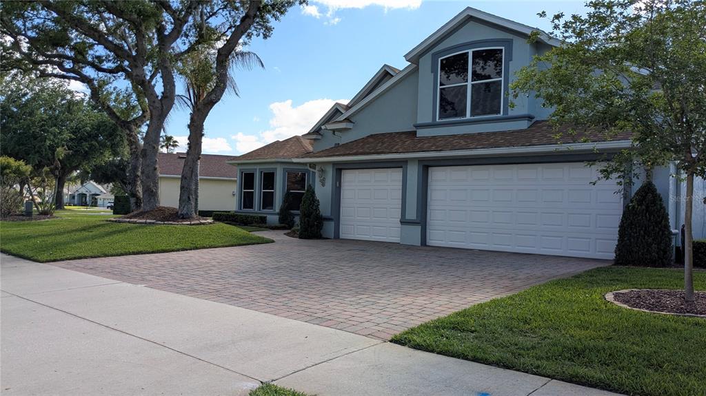 A two-story house with a paved driveway, two garage doors, and a blue exterior — 112 HALLSTROM COURT, DEBARY, FL