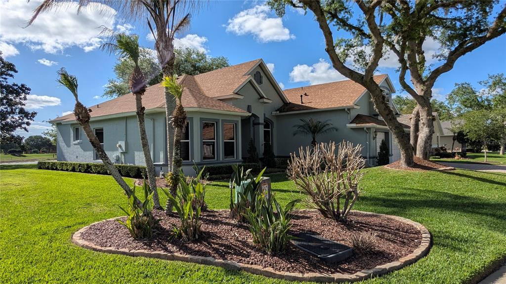 A single-story house with a tan exterior, brown roof, and landscaped front yard — 112 HALLSTROM COURT, DEBARY, FL