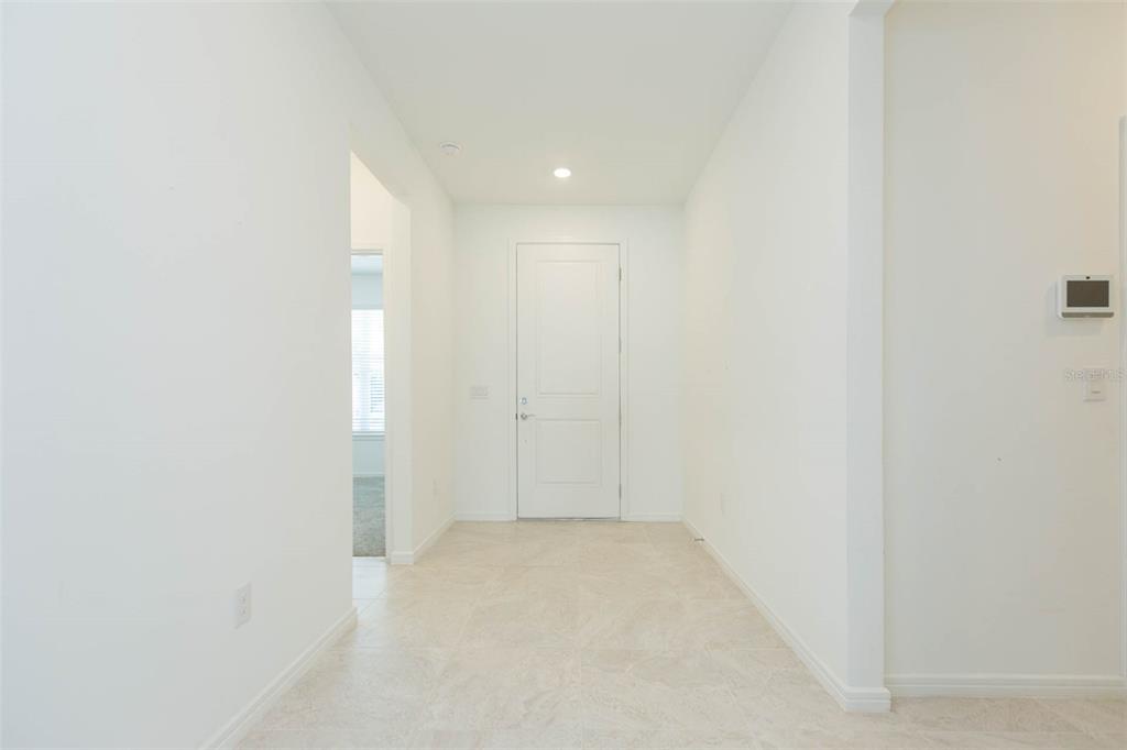 A bright entryway features white walls, tile flooring, and a single white door — 3044 FOREST MEADOW AVENUE, VALRICO, FL