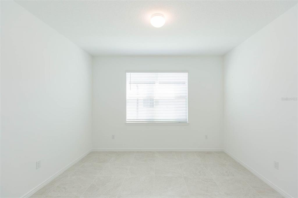 An empty room with white walls, a single window with blinds, and light-colored tile flooring — 3044 FOREST MEADOW AVENUE, VALRICO, FL
