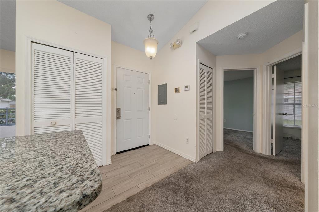 An entryway features a white door, louvered closets, tile flooring, and a carpeted hallway — 1262 LUCAYA CIRCLE, ORLANDO, FL