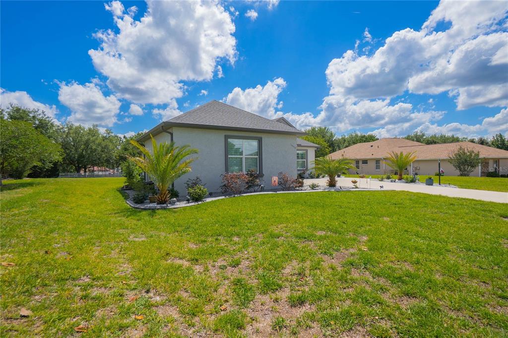 A single-story house with a gray exterior, a hip roof, and a landscaped front yard — 1555 E SEATTLE SLEW CIRCLE, INVERNESS, FL