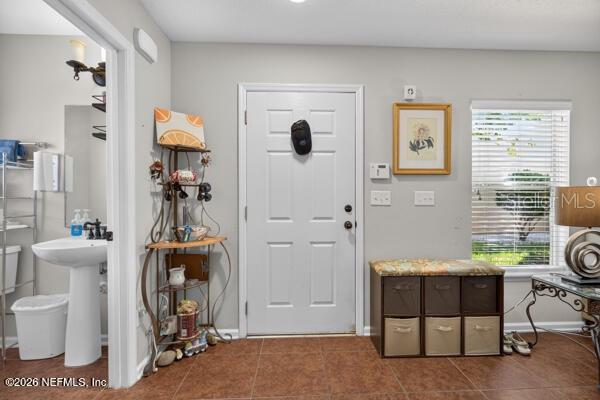 An entryway features a white door, a pedestal sink, and a storage bench — 541 CABERNET, ST AUGUSTINE, FL