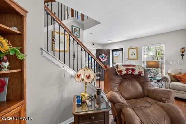 A living room features a staircase with iron railings, a recliner, and a side table — 541 CABERNET, ST AUGUSTINE, FL