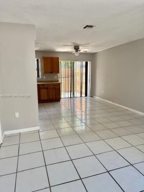 An open-concept living area features light-colored floor tiles, a ceiling fan, and a small kitchen — 927 NW 7th Ct # 2, Miami FL 33136, MIAMI, FL