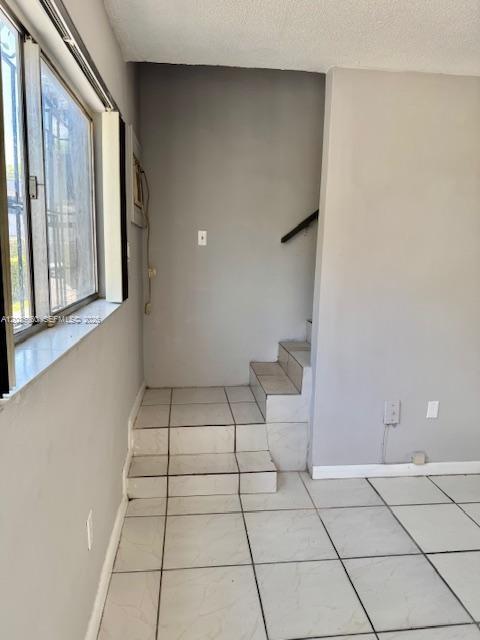 A room with white tile flooring and a small set of stairs leading upward — 927 NW 7th Ct # 2, Miami FL 33136, MIAMI, FL