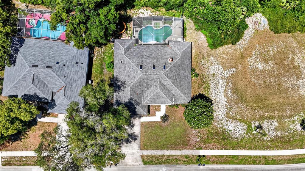An aerial view shows two houses with screened-in pools and a large adjacent vacant lot — 5988 SHADY CREEK LANE, PORT ORANGE, FL