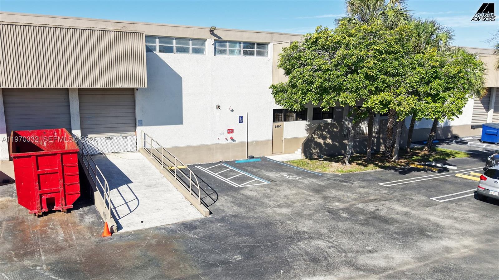 An exterior view of a commercial warehouse building with a loading ramp and parking lot — 5800 E Miami Lakes Dr E, Miami Lakes FL 33014, MIAMI LAKES, FL
