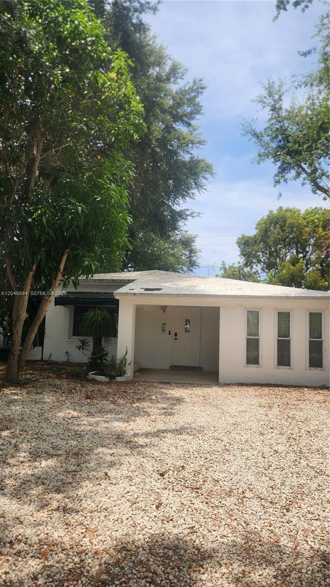 A white, single-story house with a gravel driveway and a covered front entryway — 2174 NE 182nd St, North Miami Beach FL 33162, NORTH MIAMI BEACH, FL