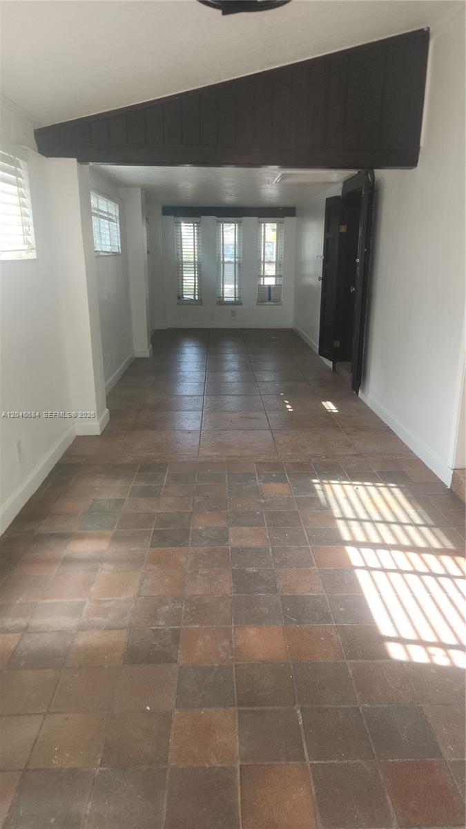 An interior room features brown tile flooring, white walls, and a dark wood ceiling beam — 2174 NE 182nd St, North Miami Beach FL 33162, NORTH MIAMI BEACH, FL