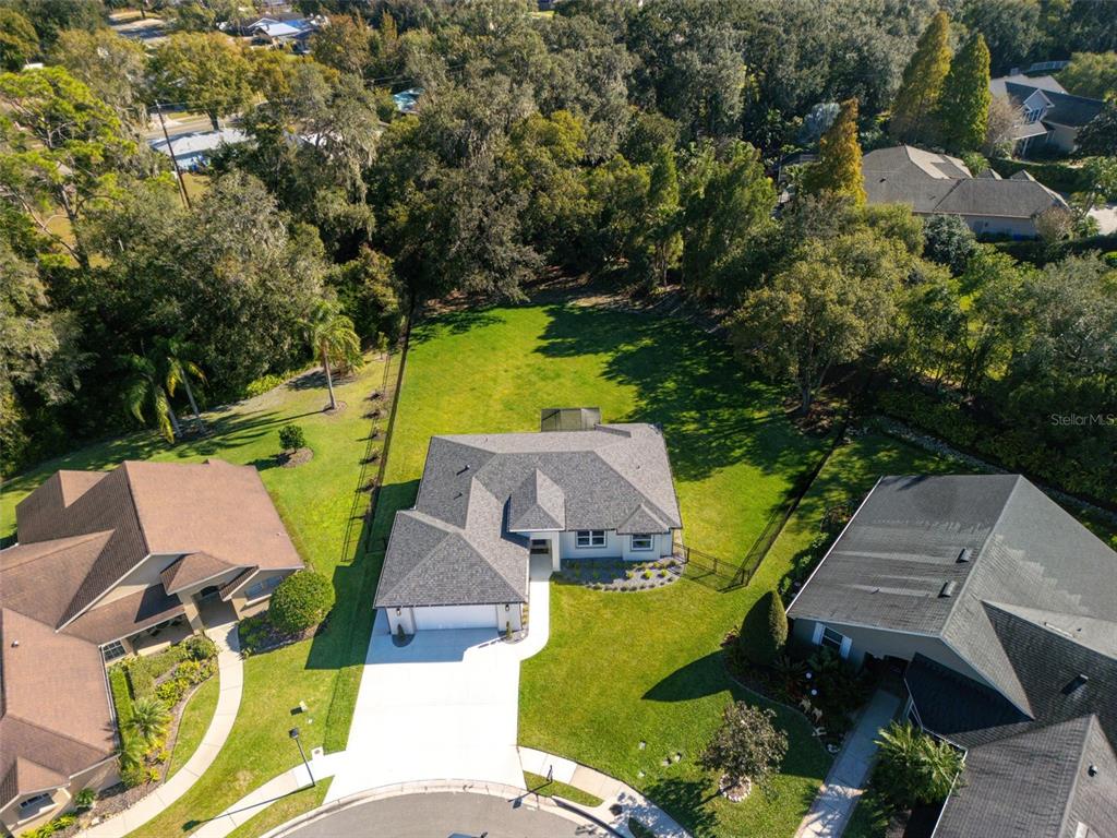 An aerial view shows a single-story house with a gray roof and a large backyard — 3160 OAKPARK DRIVE, LAKELAND, FL
