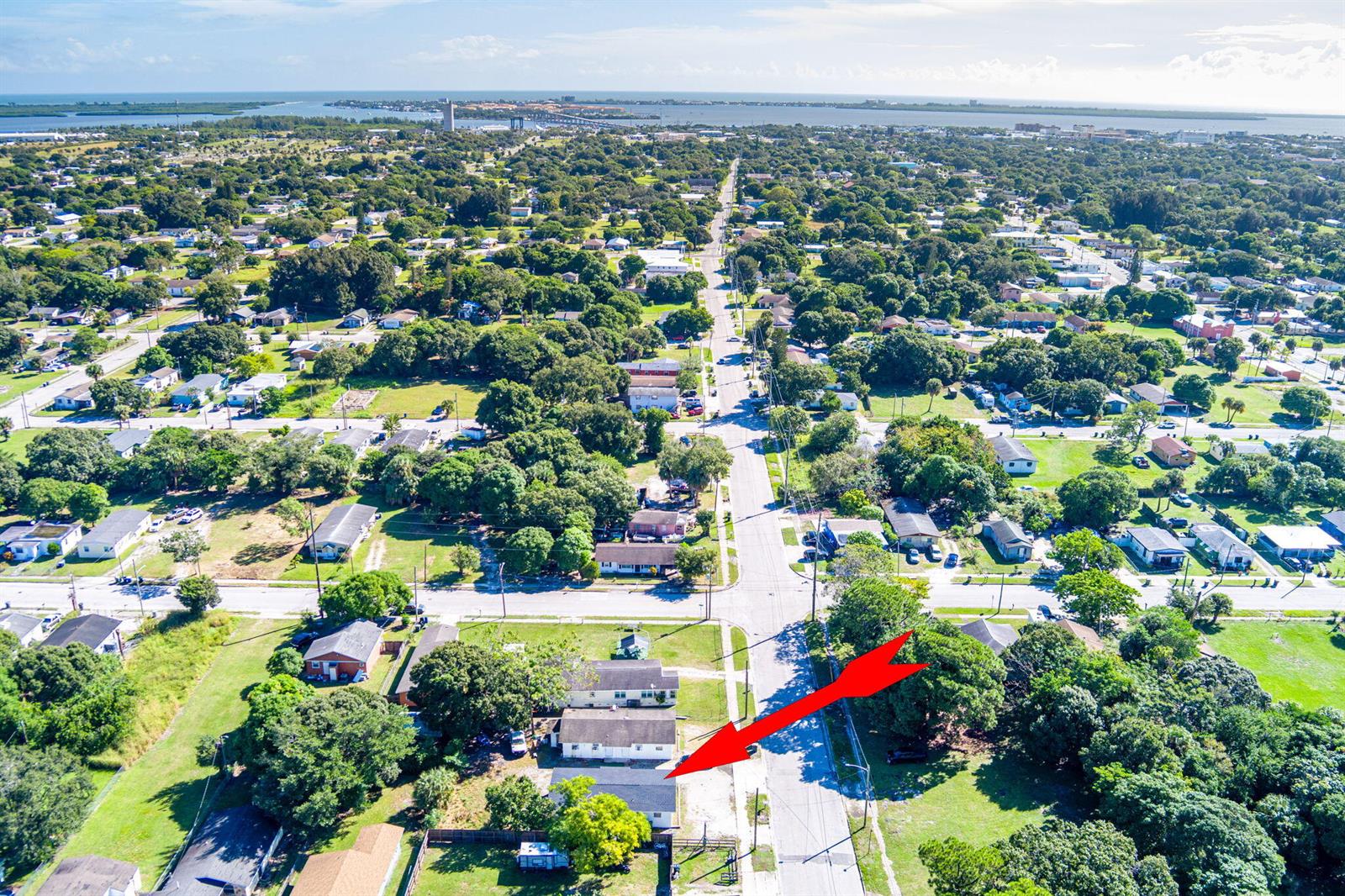 An aerial view shows a residential neighborhood with a red arrow pointing toward a house — 2108 Avenue E, Fort Pierce FL 34950, FORT PIERCE, FL