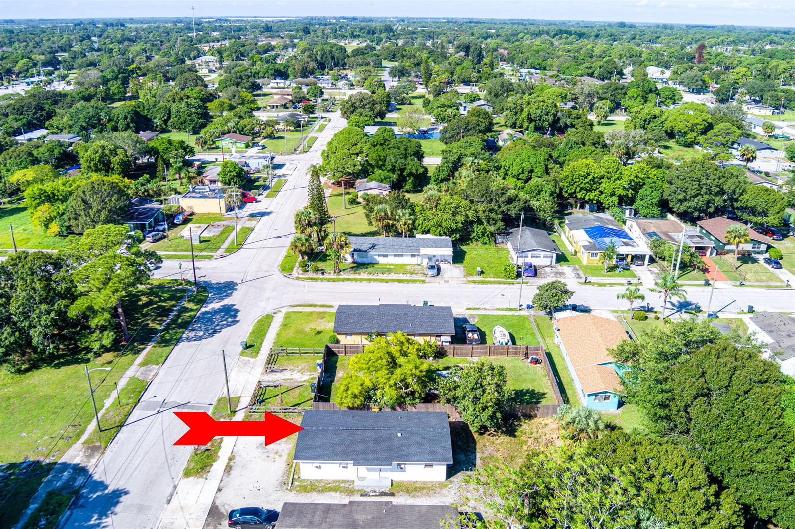 An aerial view shows a single-story house with a dark roof and a fenced yard — 2108 Avenue E, Fort Pierce FL 34950, FORT PIERCE, FL
