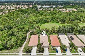An aerial view shows a row of townhomes adjacent to a wooded area and golf course — 6288 WINGSPAN WAY, BRADENTON, FL
