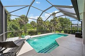 A screened-in lanai features a swimming pool with steps and a lounge chair — 6288 WINGSPAN WAY, BRADENTON, FL