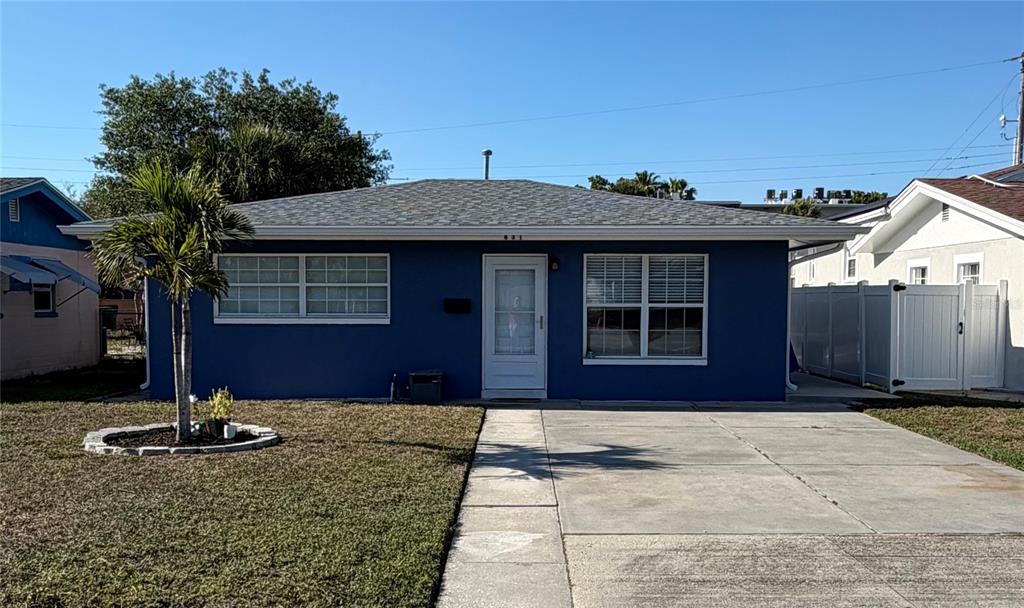 A blue, single-story house with a concrete driveway and a small palm tree in front — 631 75TH AVENUE N, ST PETERSBURG, FL