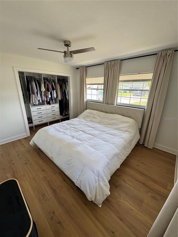 A bedroom features a white bed, a built-in closet, and light wood-look flooring — 631 75TH AVENUE N, ST PETERSBURG, FL