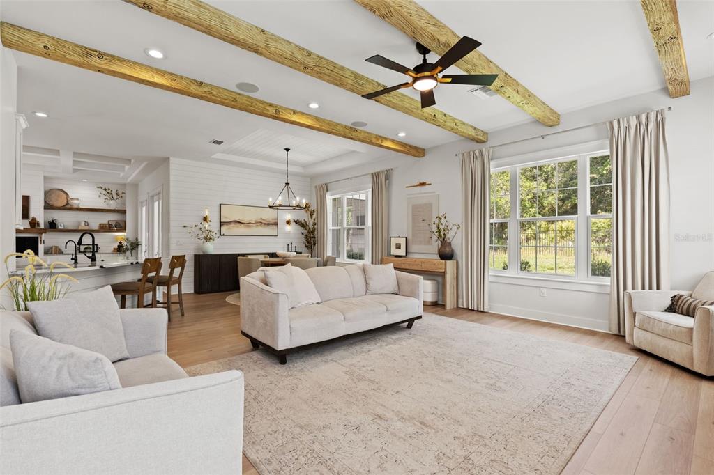 A living room features exposed wooden ceiling beams, a ceiling fan, and light-colored furniture — 20085 ENGLISH WALNUT PLACE, BROOKSVILLE, FL