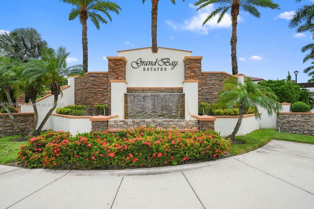 The entrance sign for Grand Bay Estates features a stone wall with a water fountain — 10016 NW 89th Ter, Doral FL 33178, DORAL, FL
