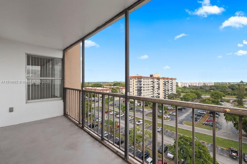 A balcony with a metal railing overlooks a parking lot and nearby apartment buildings — 4174 Inverrary Dr # 902, Lauderhill FL 33319, LAUDERHILL, FL
