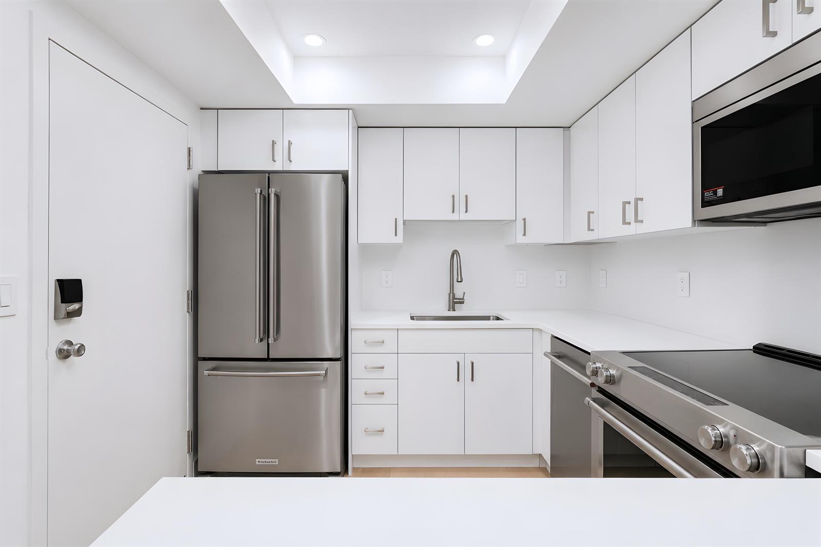 A kitchen with white cabinets, stainless steel appliances, and white countertops — 3230 S Ocean Boulevard # 410, Palm Beach FL 33480, PALM BEACH, FL