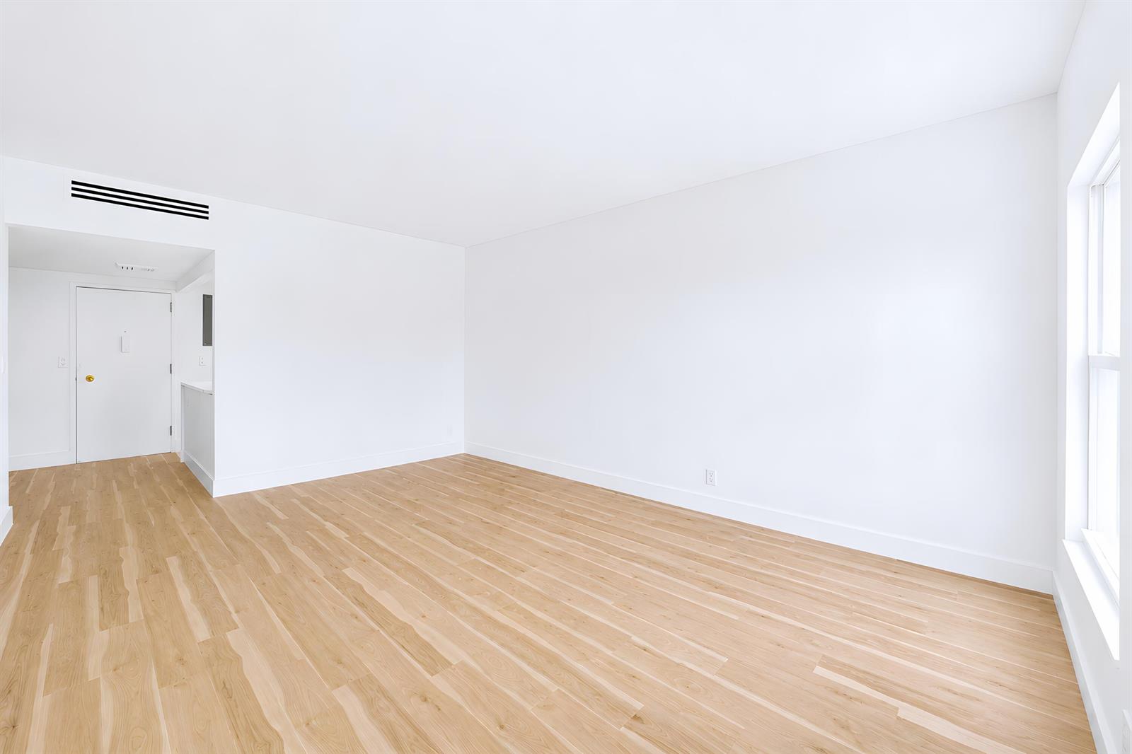 An empty room features light wood flooring, white walls, a window, and a sliding glass door — 3230 S Ocean Boulevard # 410, Palm Beach FL 33480, PALM BEACH, FL