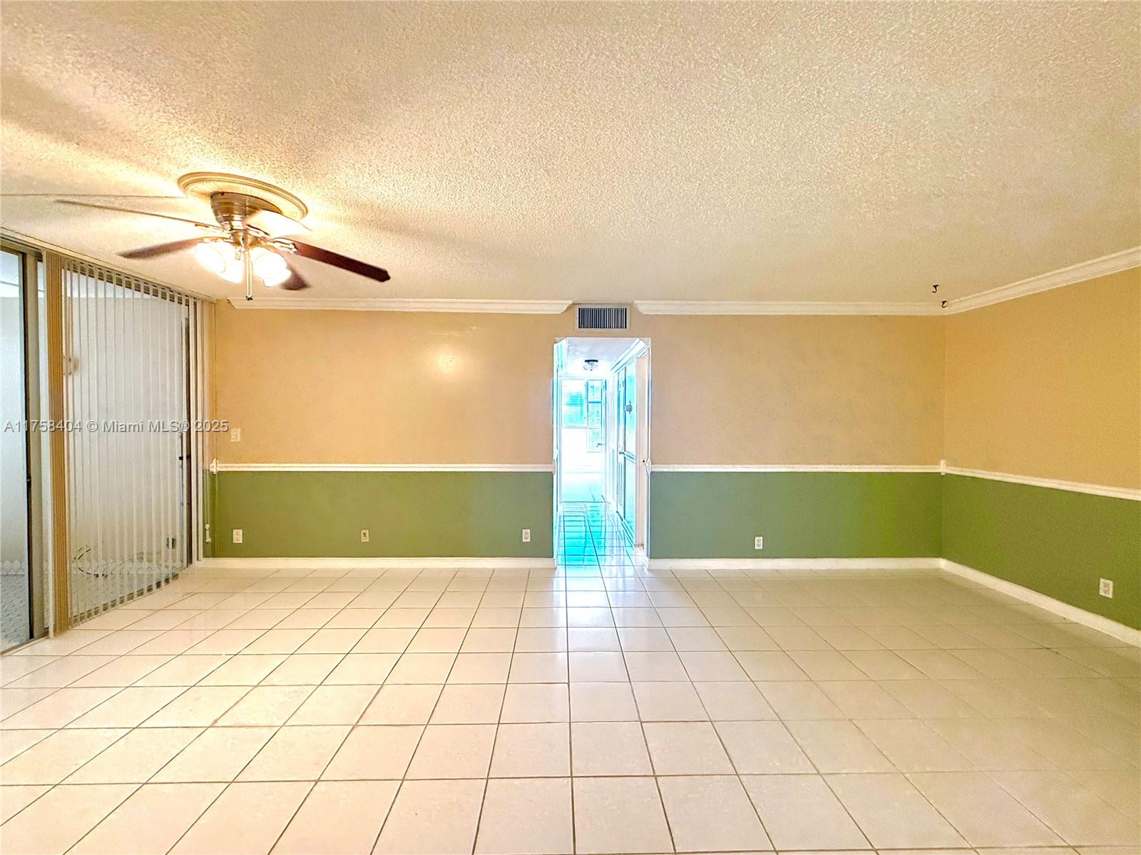 A room with white tile floors, two-toned walls, and a ceiling fan — 920 NE 199th St # 4J, Miami FL 33179, MIAMI, FL