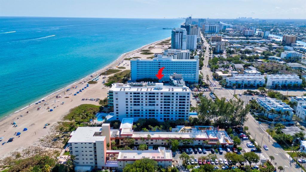 An aerial view shows a beachfront high-rise apartment complex with a red arrow pointing down — 1500 N Ocean Boulevard # 203, Pompano Beach FL 33062, POMPANO BEACH, FL