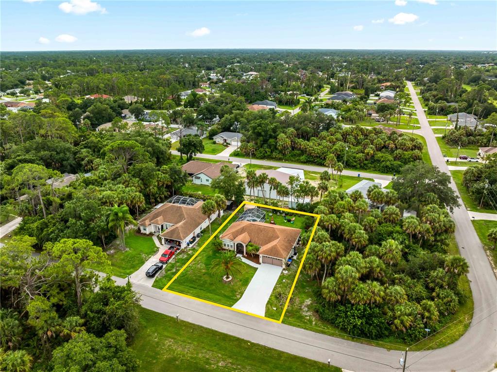 An aerial view shows a single-story house with a pool and driveway in a neighborhood — 4243 FONSICA AVENUE, NORTH PORT, FL